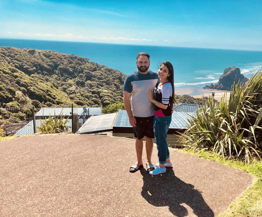 Two students at a lookout above Piha Beach and Lion Rock on Auckland's west coast