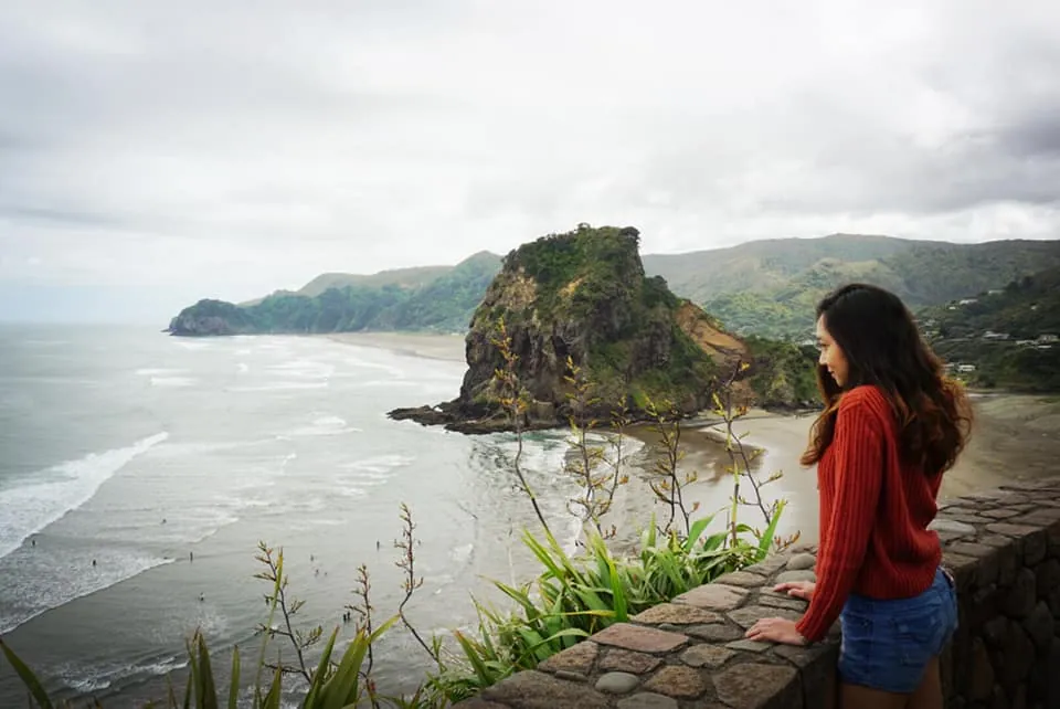 A student looking out over Lion Rock and Piha Beach on Auckland's west coast